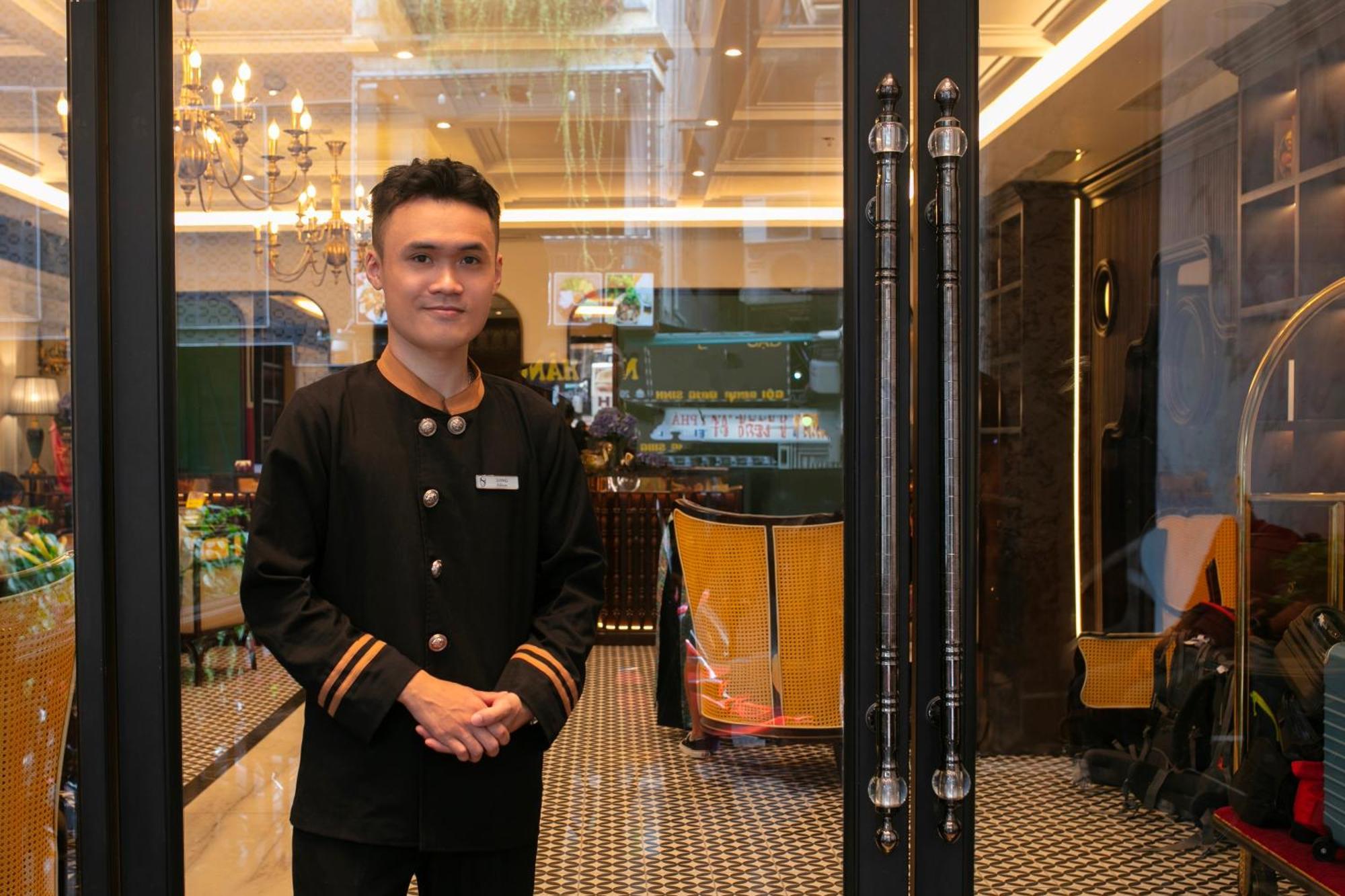 May De Ville Crown Hotel Hanoi Zewnętrze zdjęcie A doorman at the entrance of a hotel in Kuala Lumpur, Malaysia